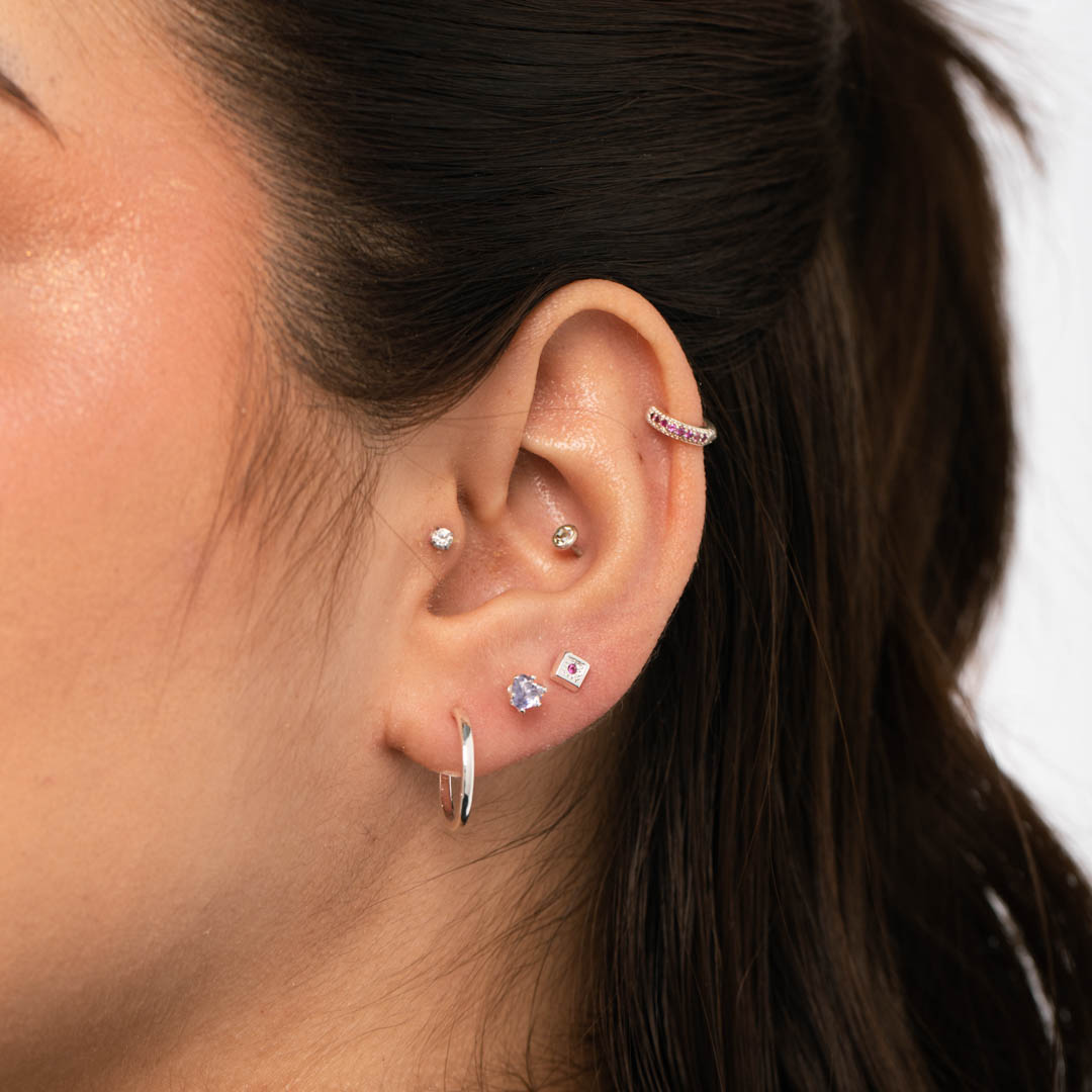 BRINCO PONTO DE LUZ CORAÇÃO PEQUENO COM 6 GARRAS ZIRCONIA LILAS - BANHADO A RODIO BRANCO