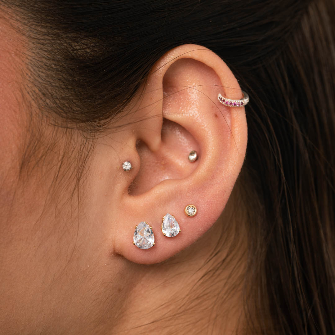 BRINCO PONTO DE LUZ DE TARRACHA OVAL COM 4 GARRAS CRISTAL GRANDE - BANHADO A OURO 18K