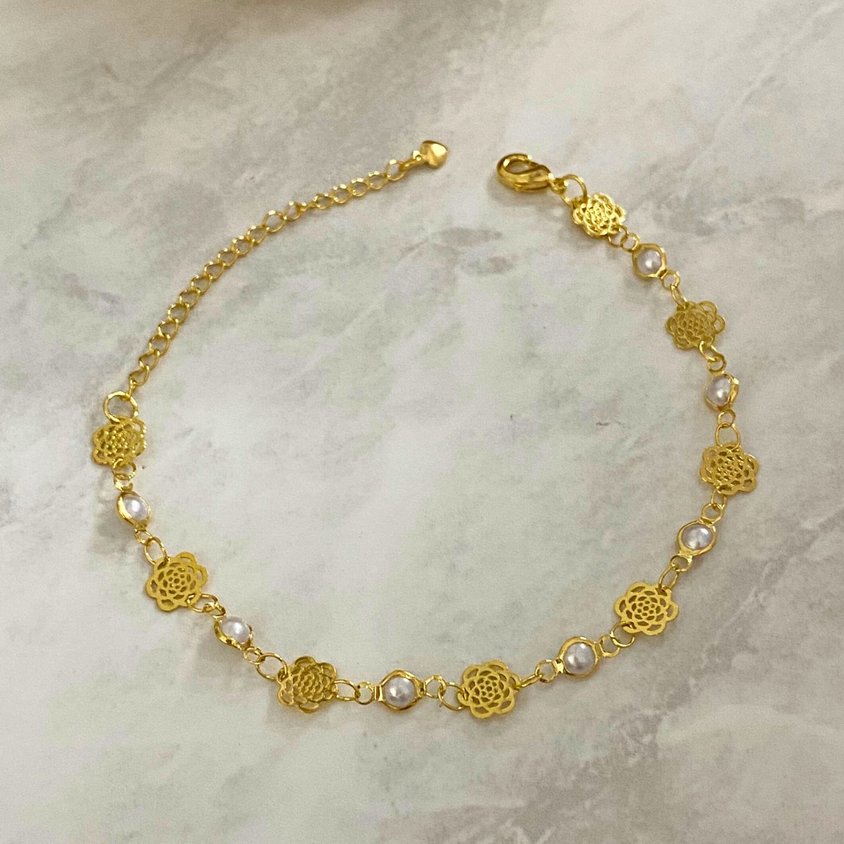 PULSEIRA COM 8 PEROLAS E 7 ROSAS DE CHAPA COM EXTENSOR