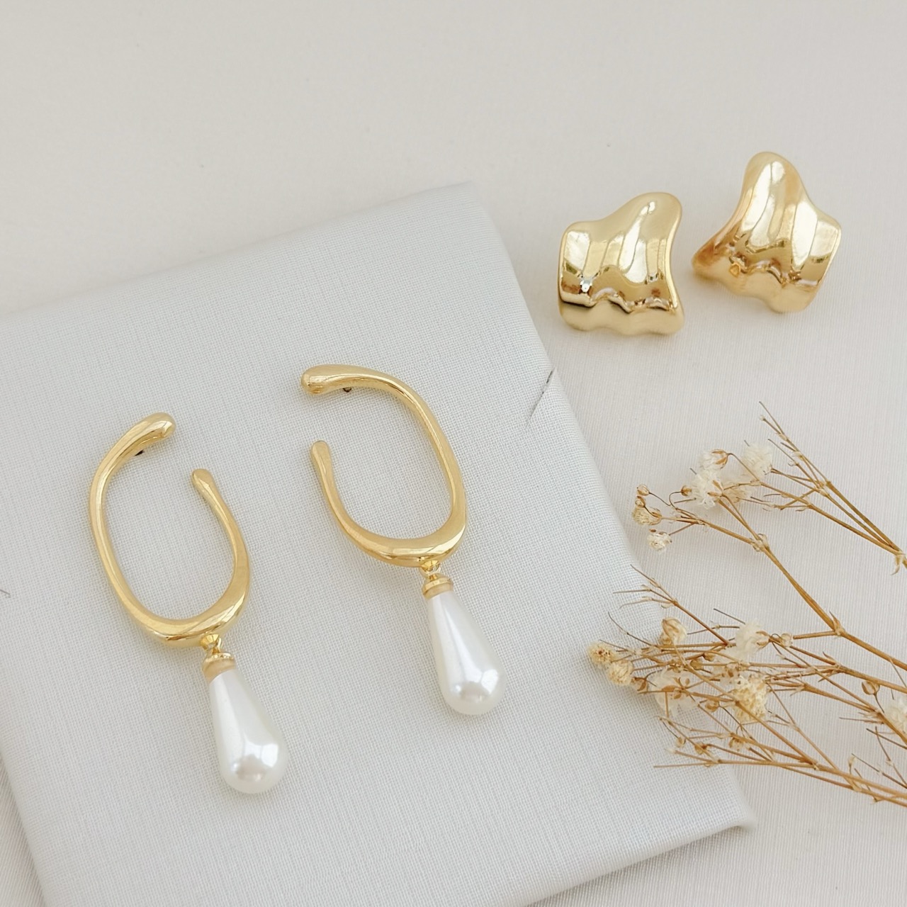 06.1868.15.O - Brinco de base formato C liso com pingente de pérola em gota