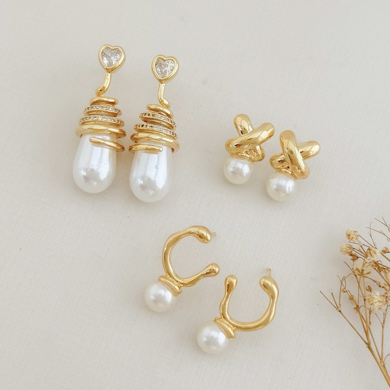 06.1871.15.O - Brinco de formato X liso com pérola em parte inferior