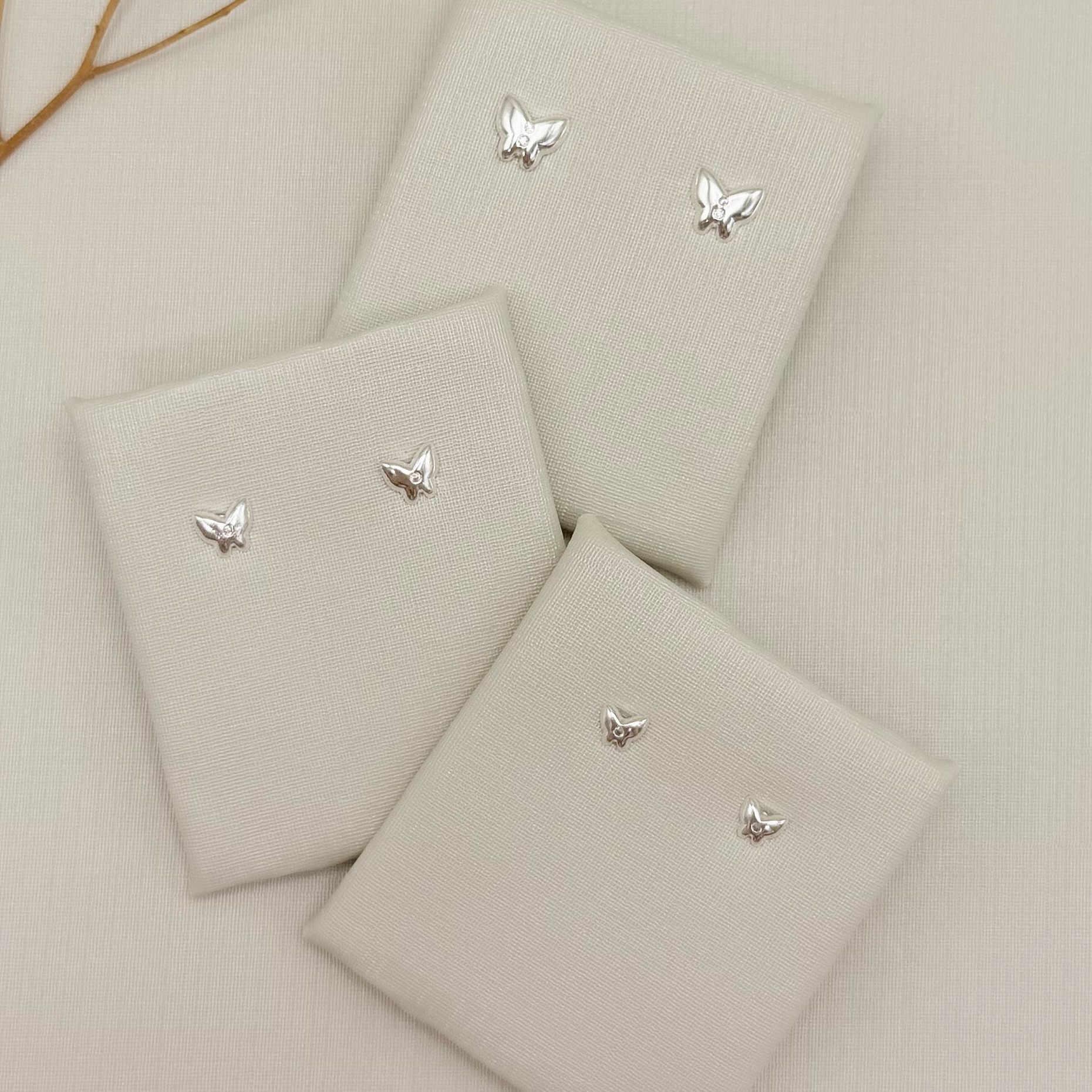 07.2819.1.S - Brinco de borboleta lisa com duas zircônias no centro, maior de três.