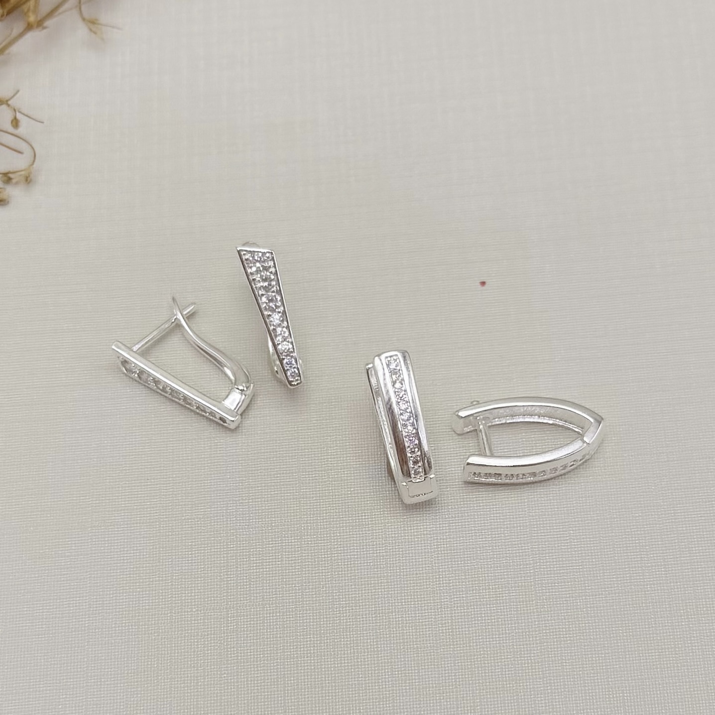 05.3095.1.S - Argola frente reta cravejada com detalhe em cima pontudo, parte de cima mais larga e parte debaixo mais estreita.