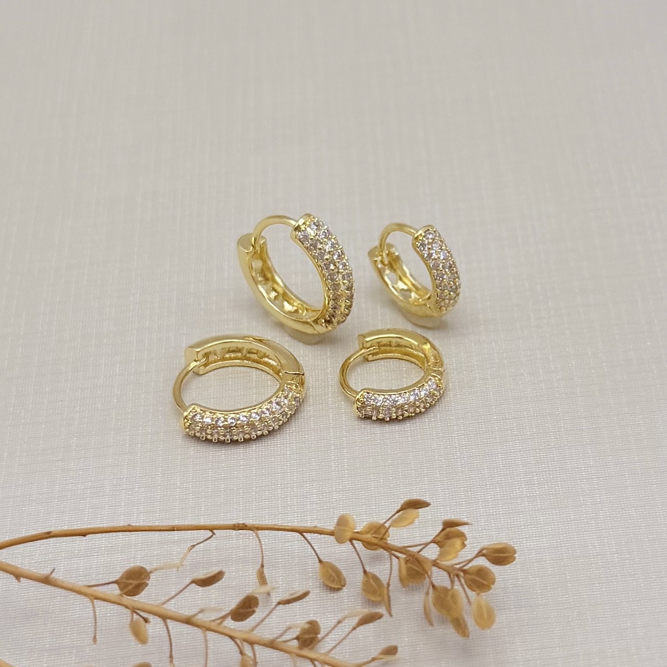 05.3100.1.O - Argola clássica cravejada acabamento côncavo 12mm, menor de duas.