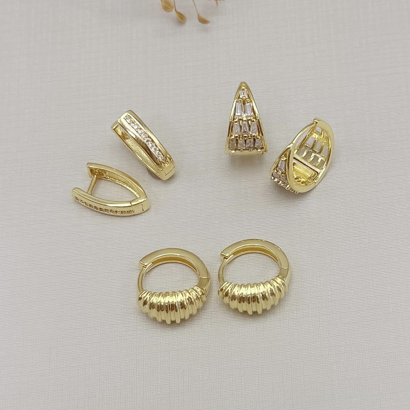 05.3102.1.O - Argola formato V com uma fileira de zircônias na frente e detalhe lateral nas zircônias largo e liso.