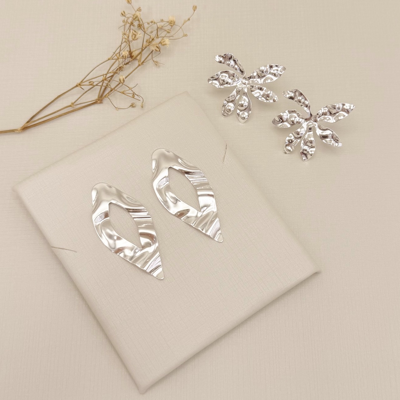 06.1324.0.S - Brinco folha de bordo com chapa trabalhada com amassados circulares.