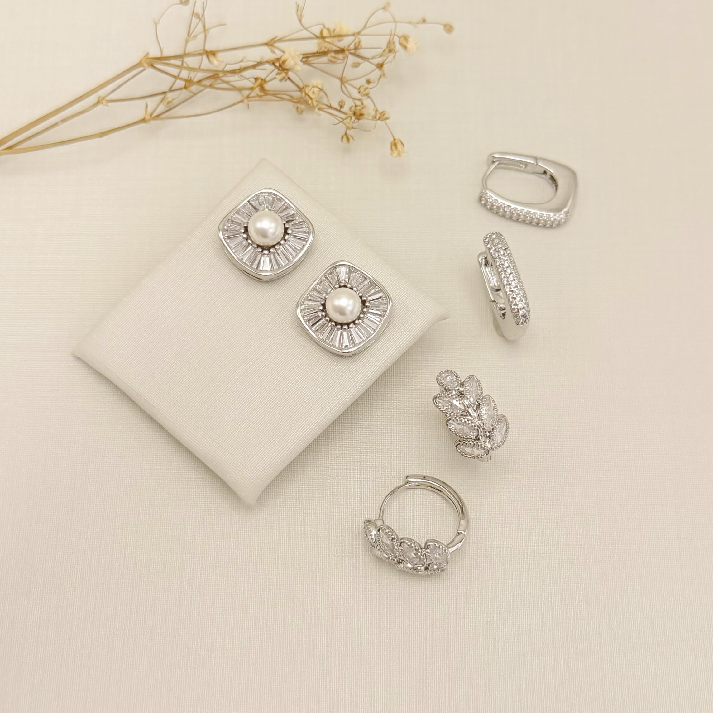 06.1329.15.B - Brinco quadrado com pérola no centro e borda em zircônias baguetes.