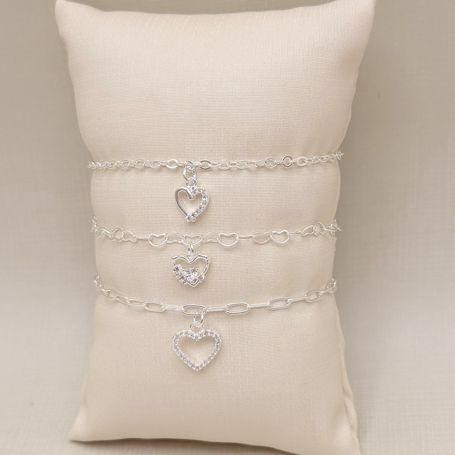 12.2271.1.S - Pulseira pingente de silhueta de coração com uma lateral cravejada, elo americano 2,4mm de espessura.