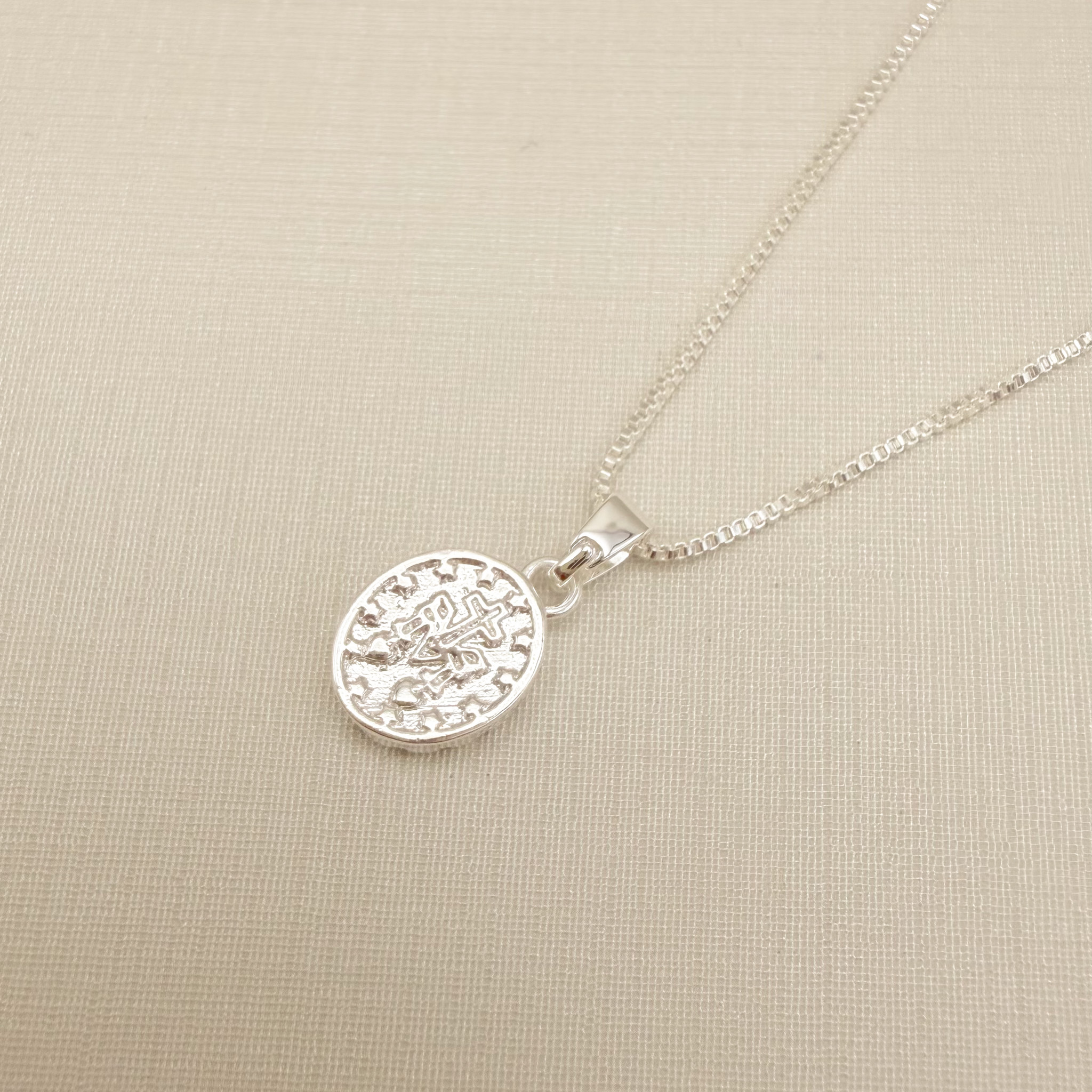 09.2438.1.S - (45) Colar pingente oval com Nossa Senhora das Graças no centro e borda cravejada e verso o Monograma Mariano.