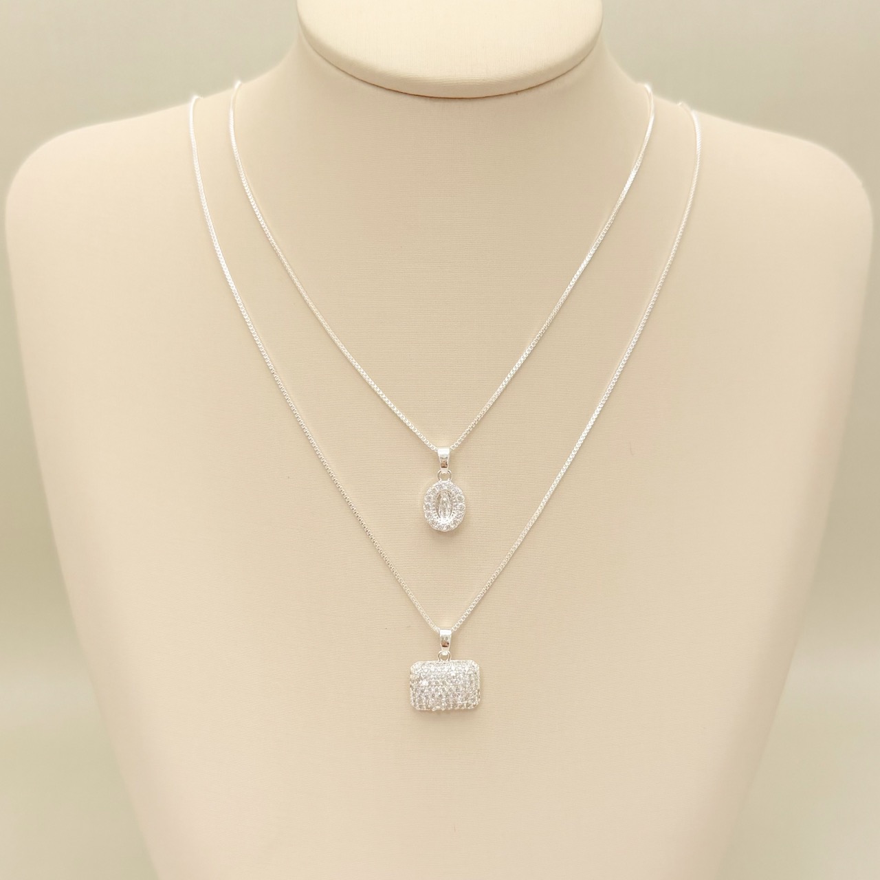 09.2438.1.S - (45) Colar pingente oval com Nossa Senhora das Graças no centro e borda cravejada e verso o Monograma Mariano.