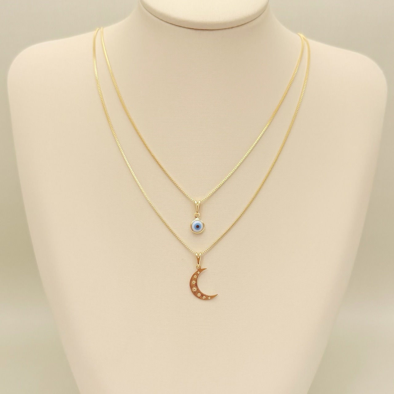 09.2441.0.O - (45) Colar com pingente lua com desenho de sete sóis/sol em baixo relevo.