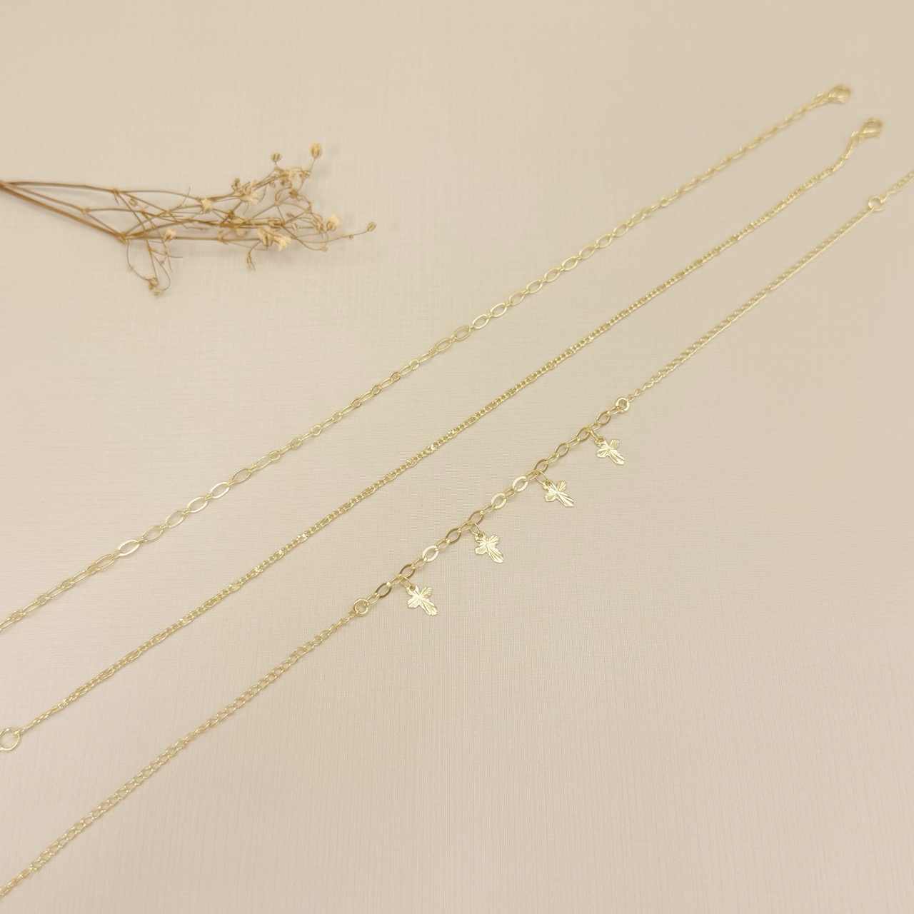 14.0331.0.O - Tornozeleira elo americano 3mm com quatro pingentes de cruz diamantadas.