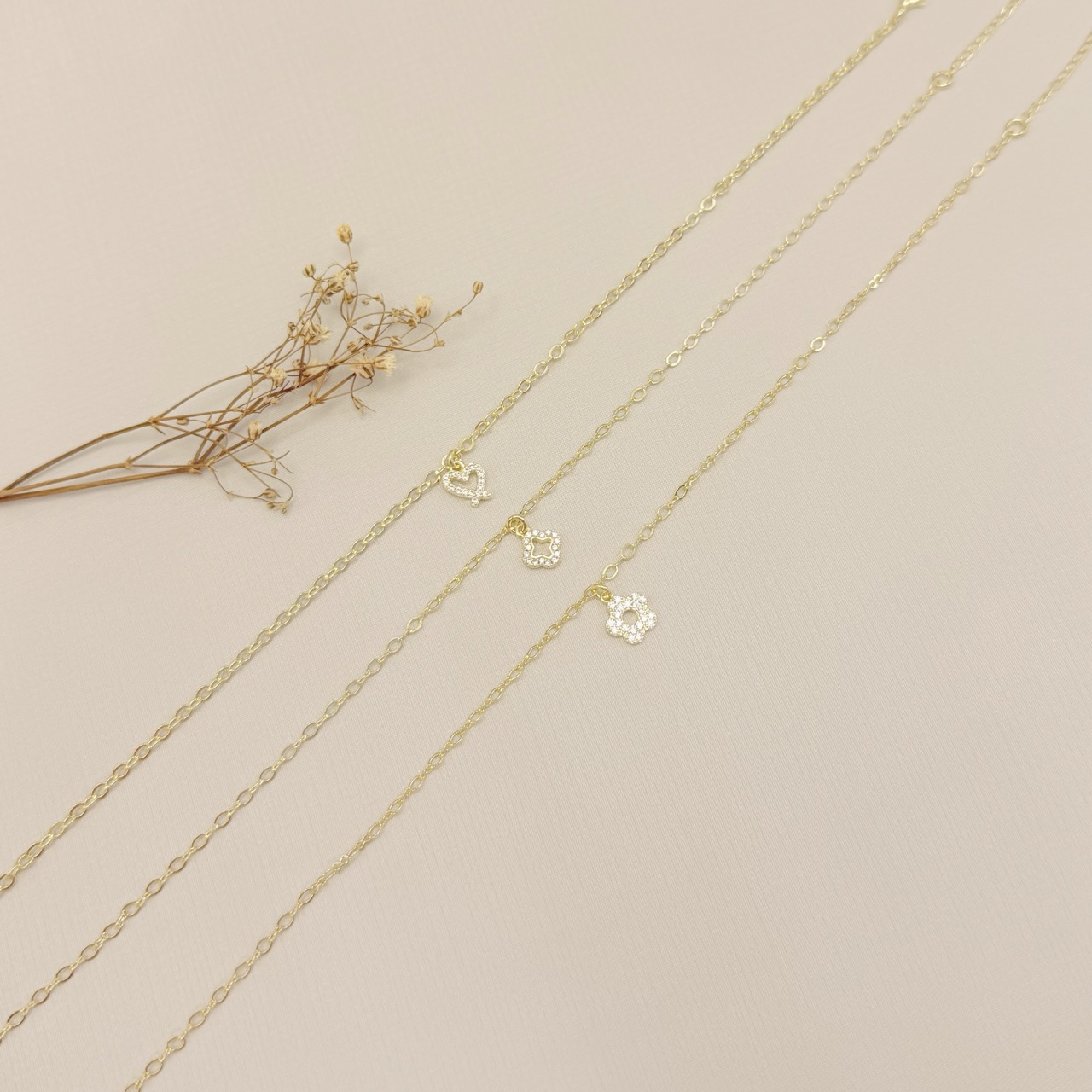 14.0336.1.O - Tornozeleira com pingente de silhueta de flor alhambra cravejada, insp. Van-Cleef, malha elo oval e elo infinito.