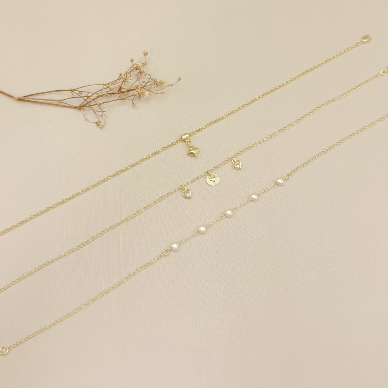 14.0315.0.O - Tornozeleira de elos simples com pingentes de corações, dois em pedra e central em moeda