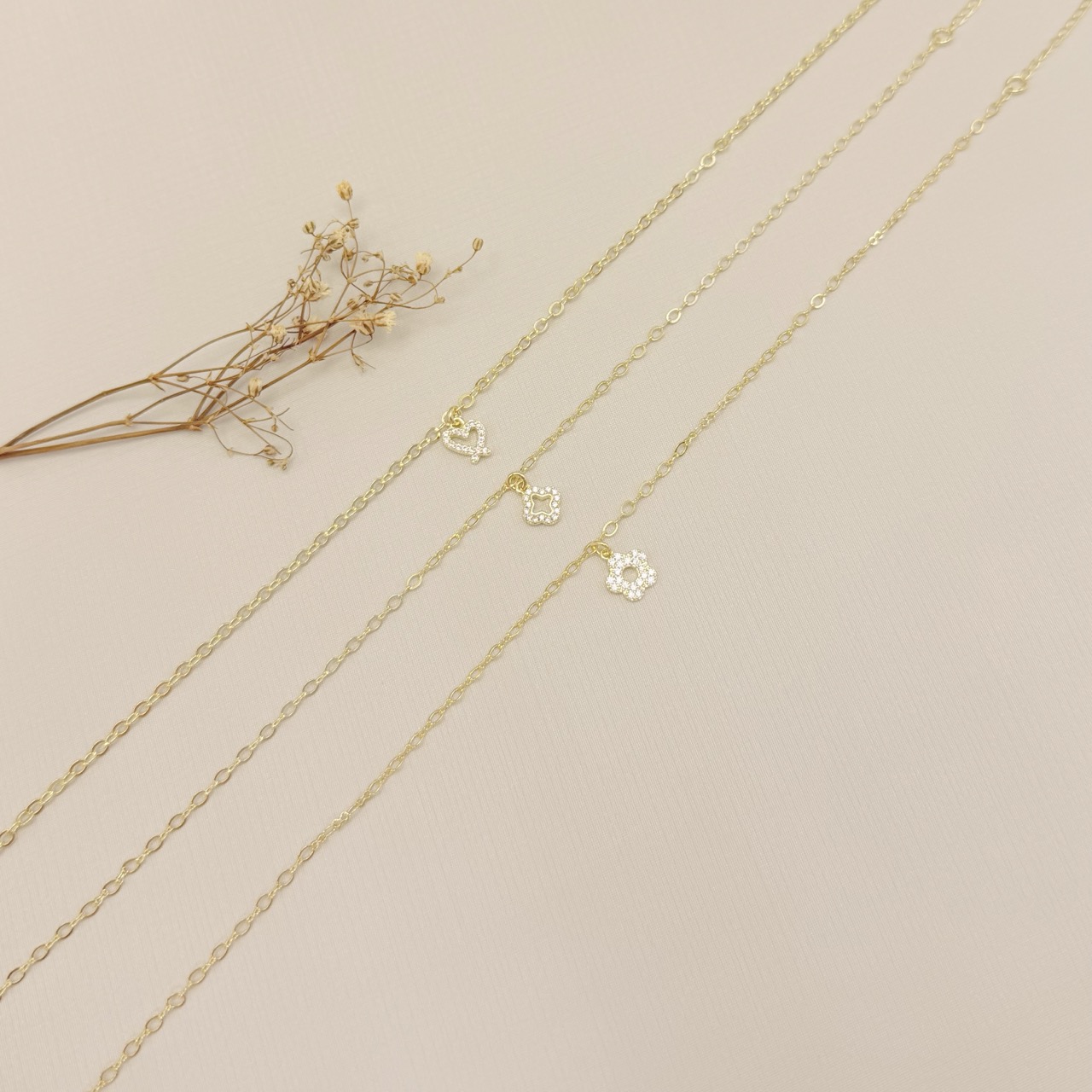 14.0317.1.O - Tornozeleira de leos ovais com pingente de silhueta coração desenhado cravejado