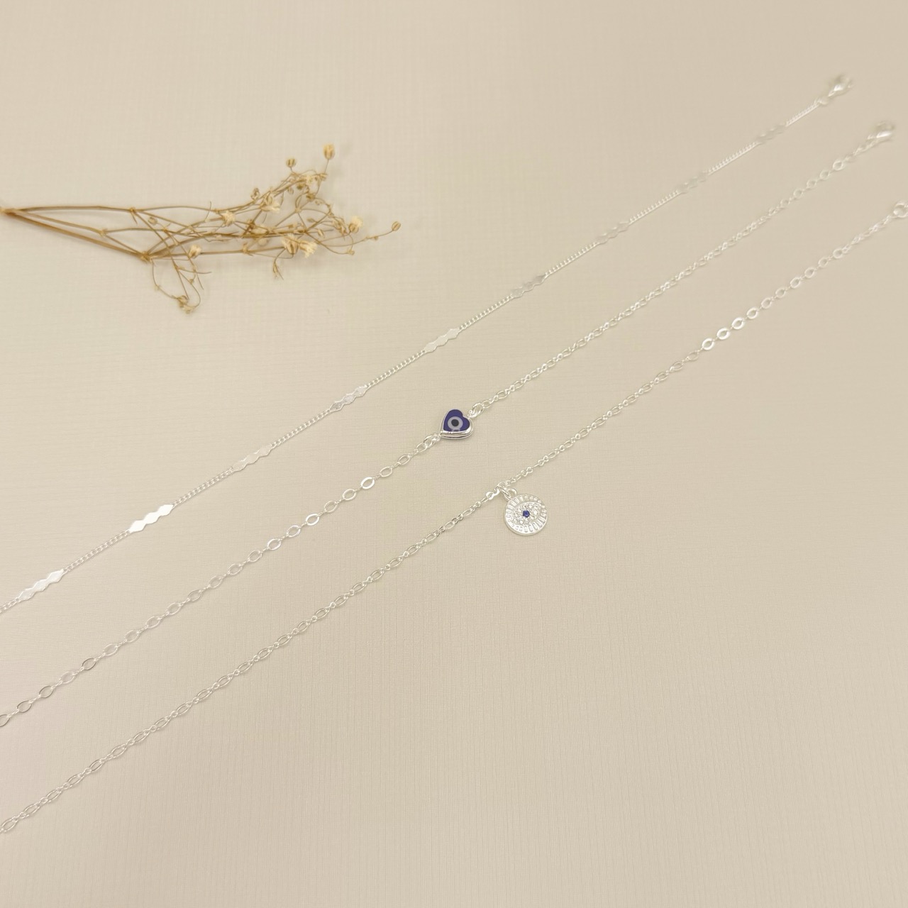 14.0318.4.S - Tornozeleira de elos ovais com pingente moeda com olho grego cravejado