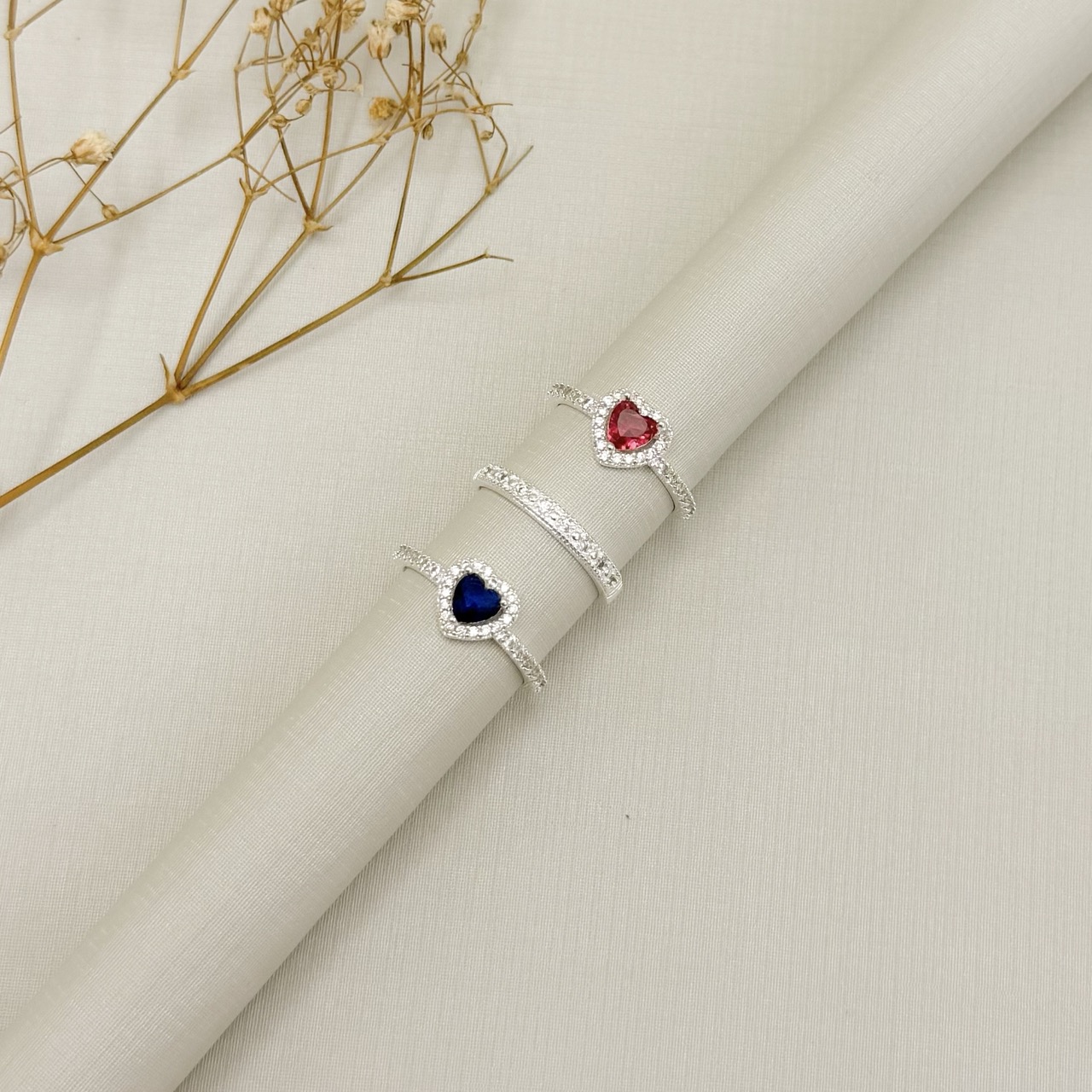 03.2573.4.S - (24) Anel solitario de formato coração com um linha de aura e aro lateral cravejado