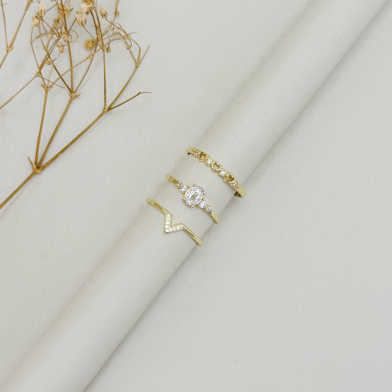 03.2597.1.O - (21) Anel de aro liso com três silhuetas de coração e pontos de luz intercalados