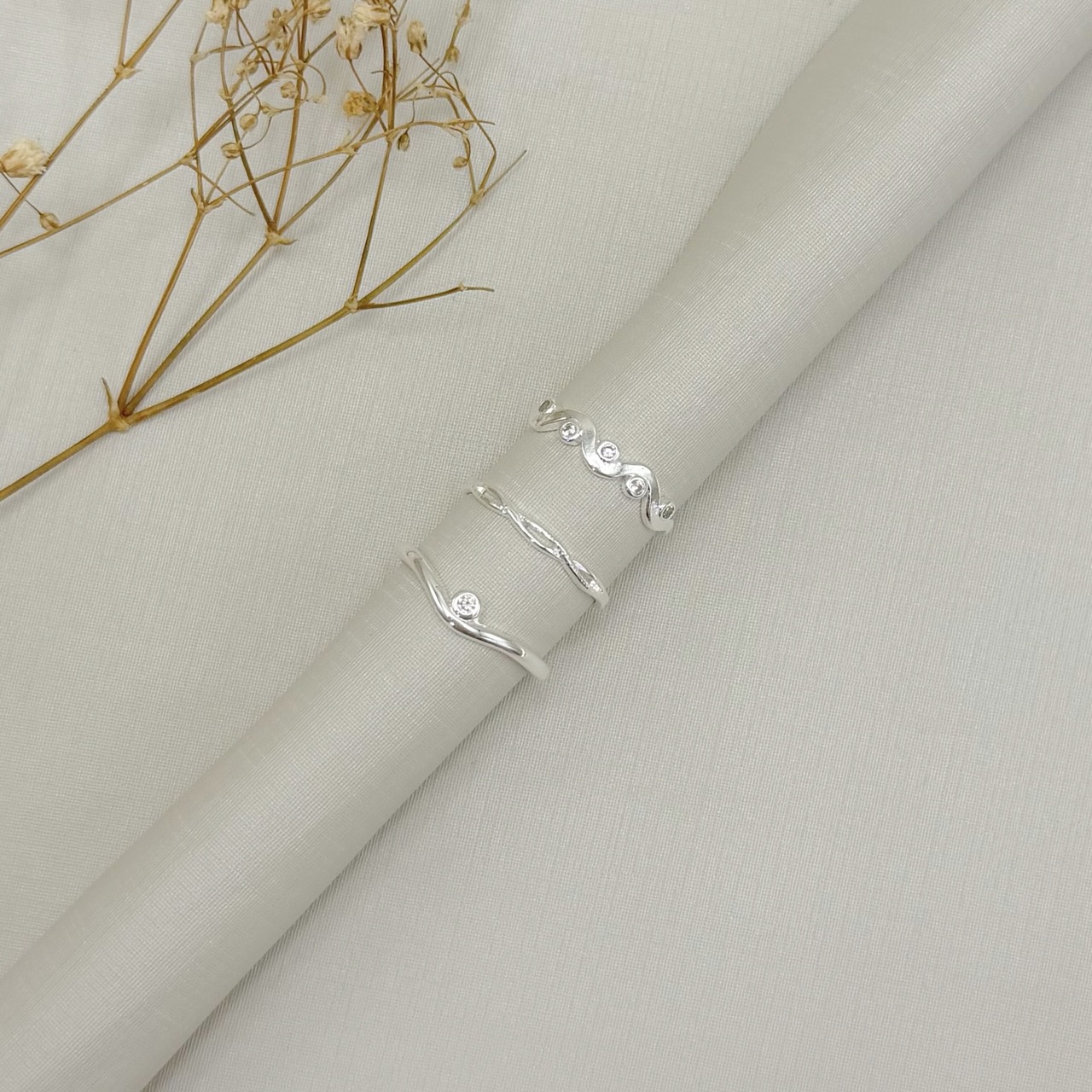 03.2599.1.S - (15,5) Anel de aro liso ondulado com ponto de luz em cravação inglesa