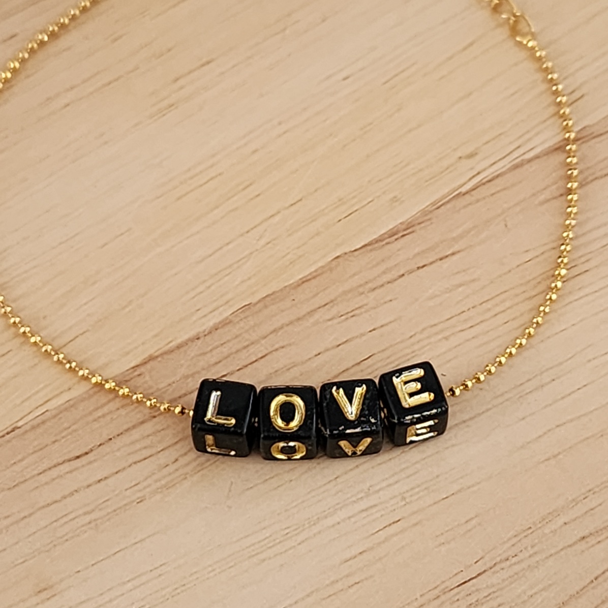 PULSEIRA BOLINHAS COM LETRAS PRETAS LOVE