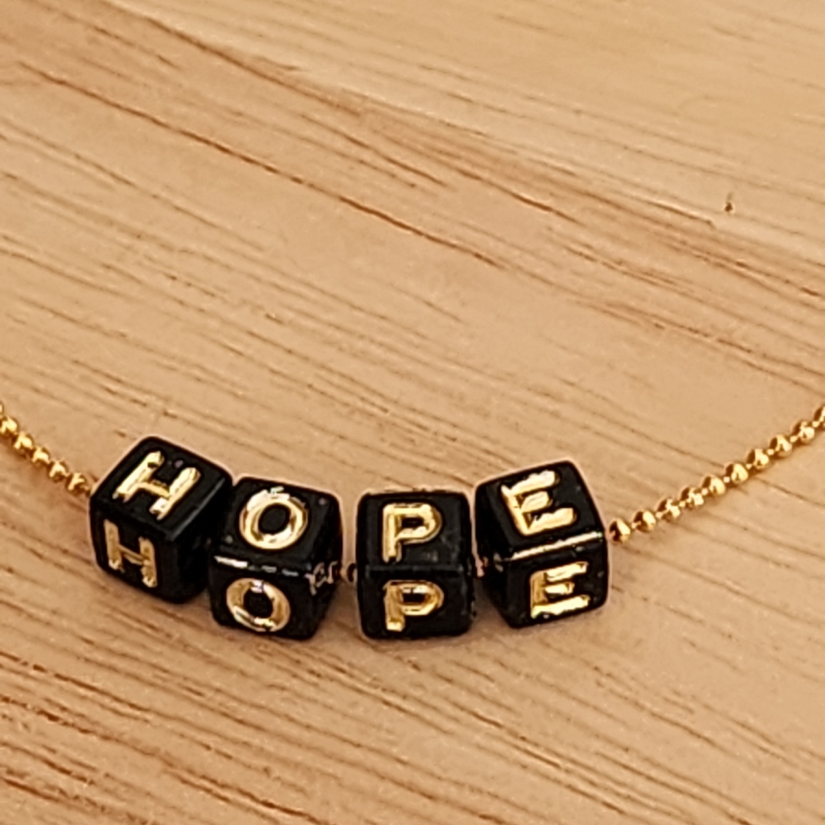 PULSEIRA BOLINHAS COM LETRAS PRETAS HOPE