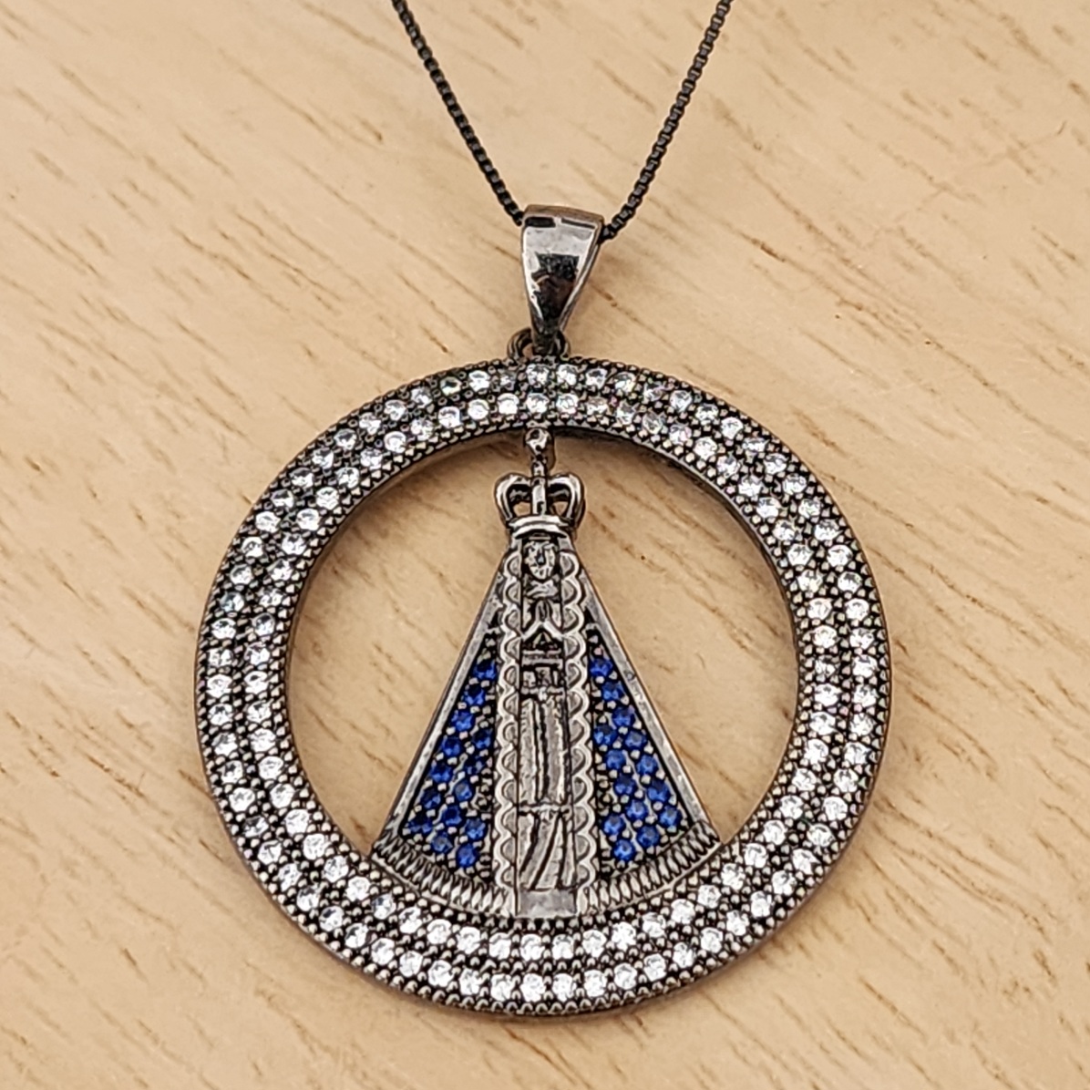 COLAR RÓDIO NEGRO PINGENTE CRAVEJADO COM MICROZIRCÔNIAS CRISTAL E AZUL DE NOSSA SENHORA