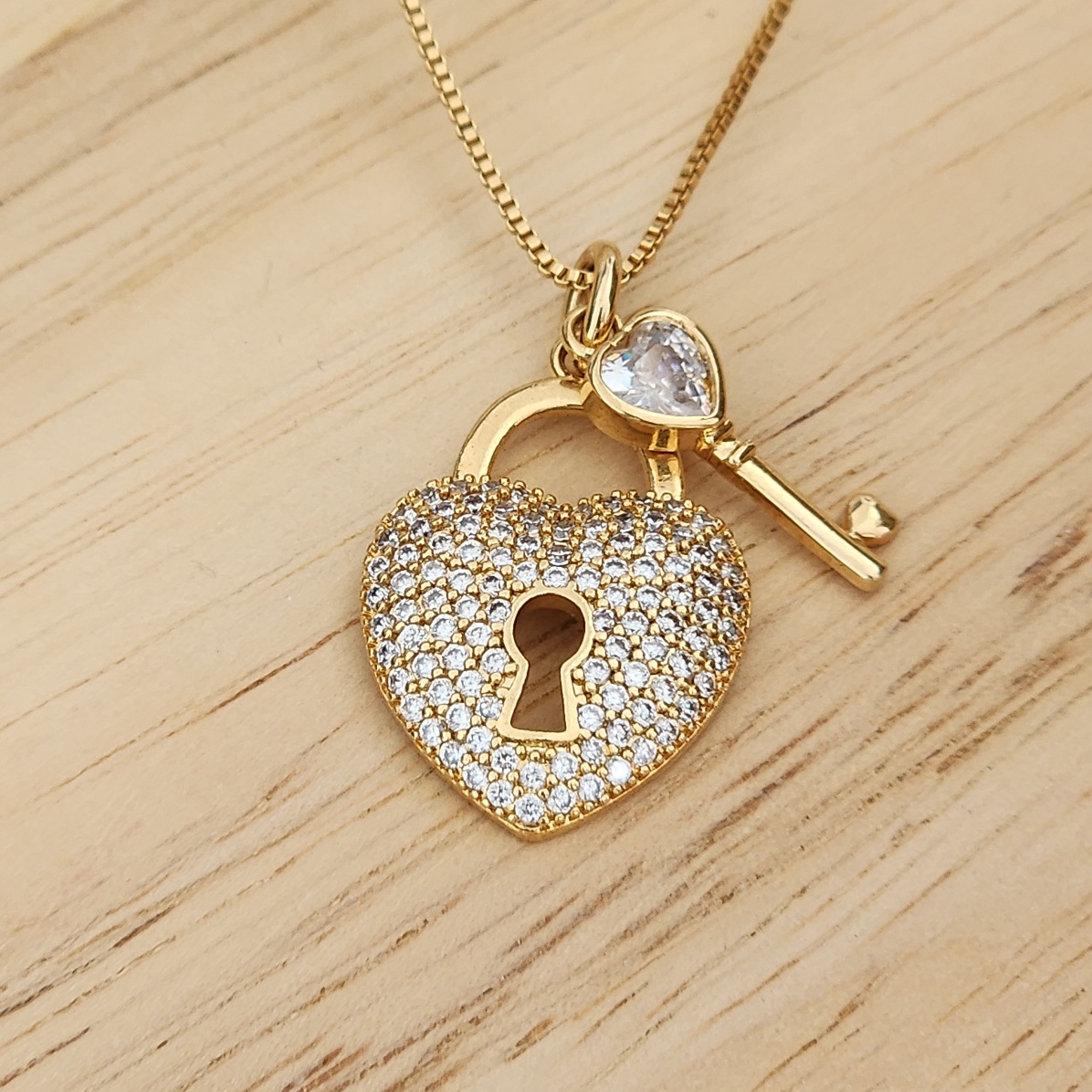 COLAR DOURADO CORAÇÃO E CHAVE CRAVEJADO EM MICROZIRCÔNIAS CRISTAL