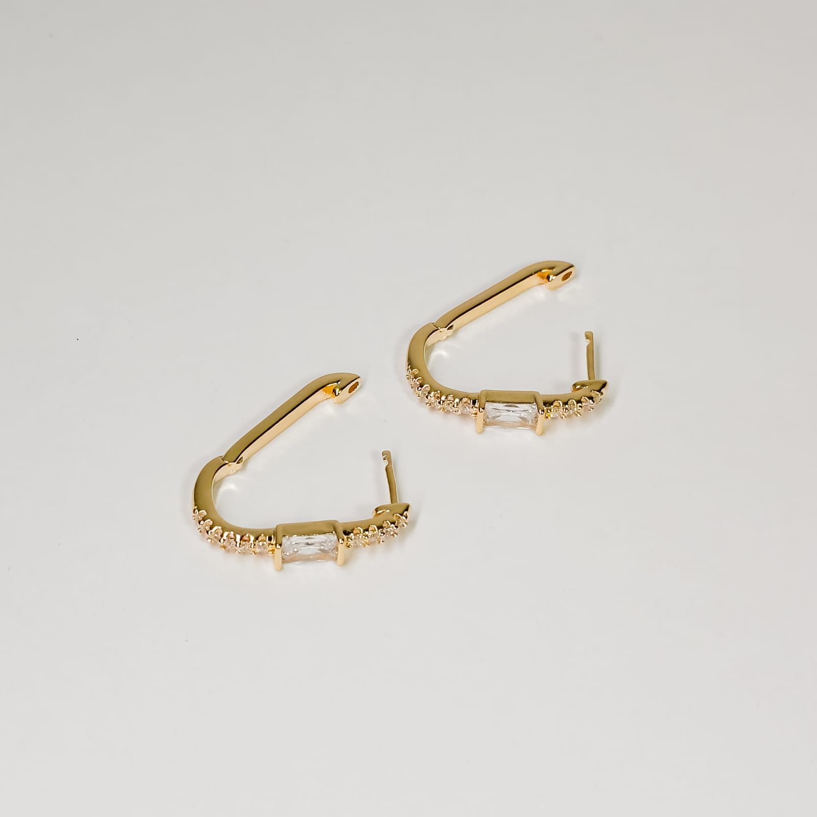 Argola cristal com cristal oval no centro e zircônias cravejada banhado a ouro 18k