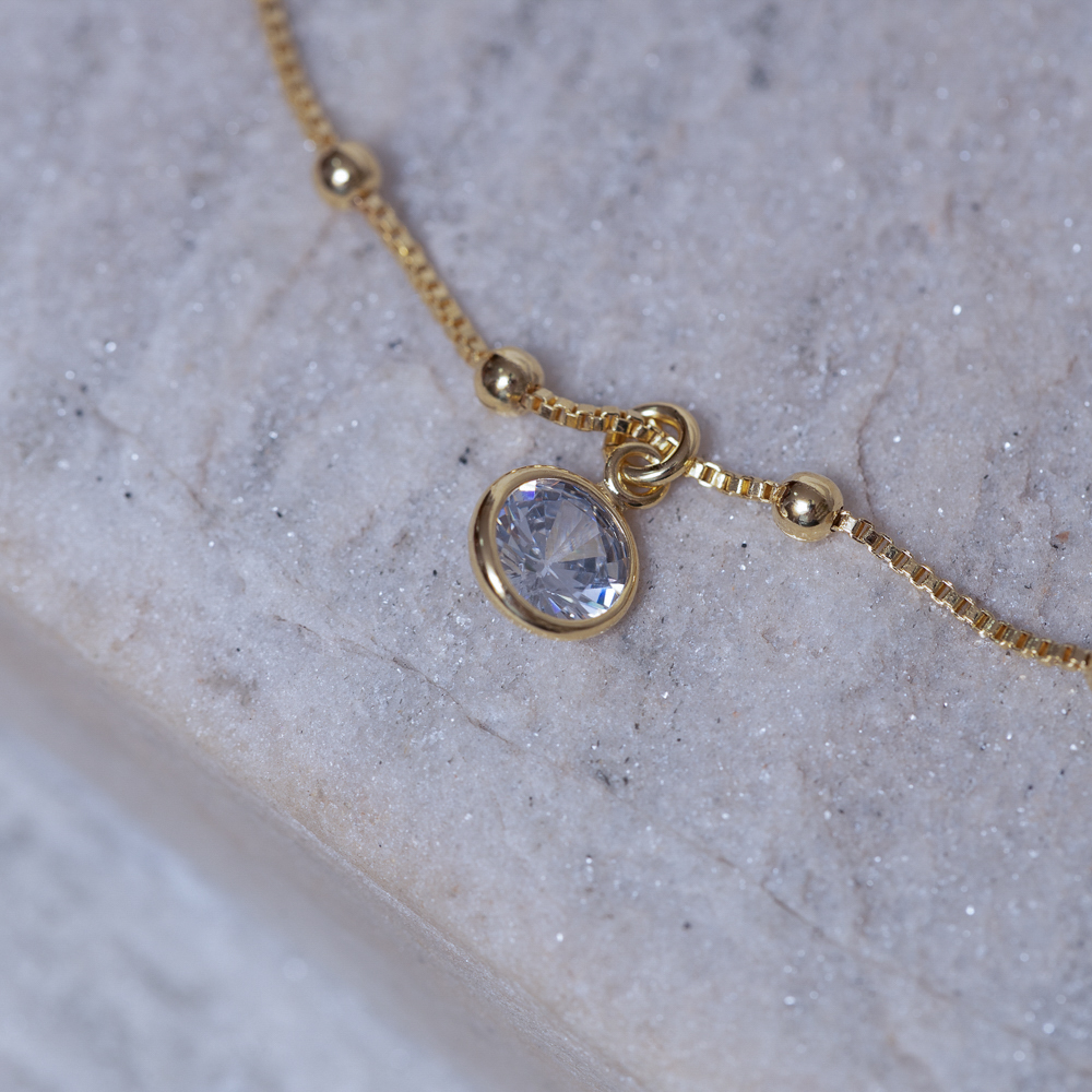 TORNOZELEIRA BOLINHAS COM PONTO DE LUZ BANHO OURO 18K