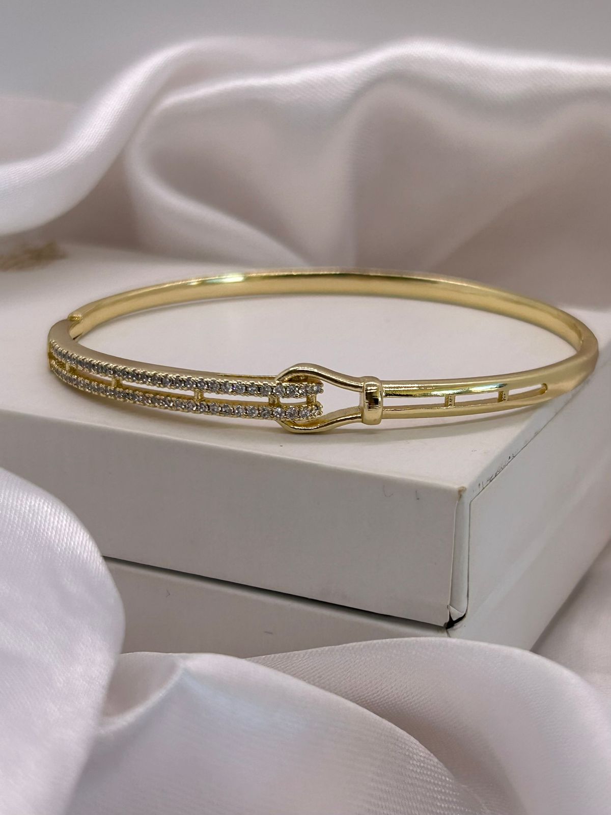 Bracelete dourado com pedras cravejadas