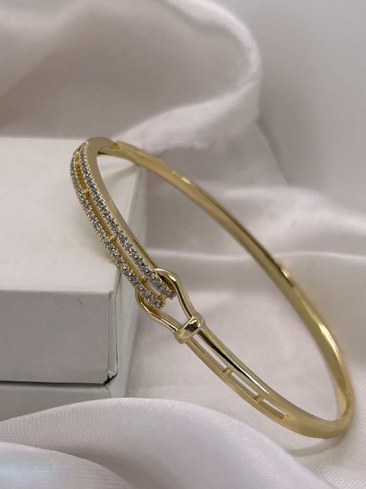 Bracelete dourado com pedras cravejadas