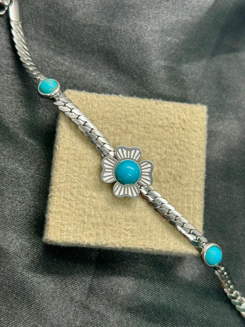 Pulseira de aço com flor pedra azul